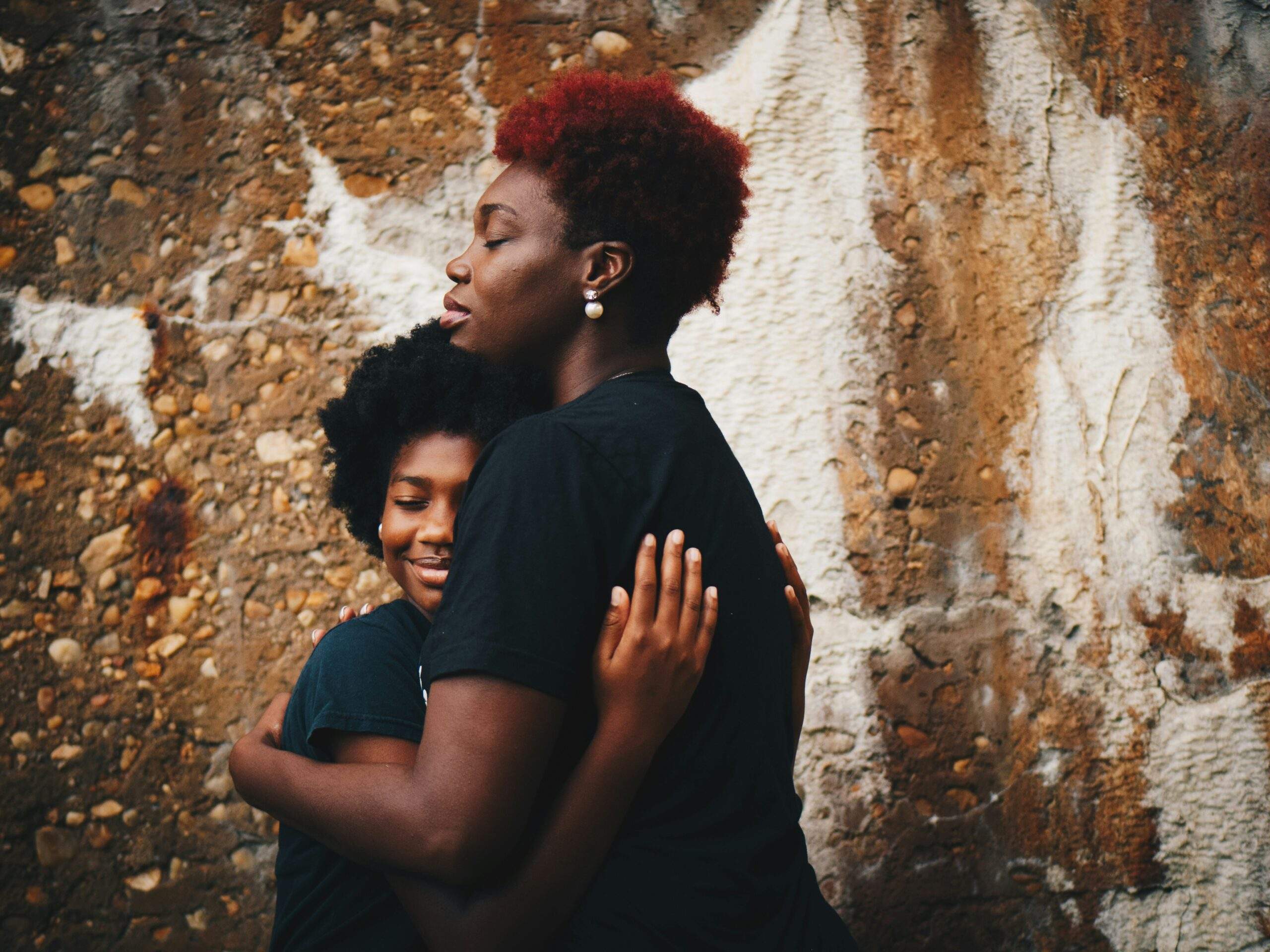 Mom comforting daughter, showing her it's okay to feel sadness.